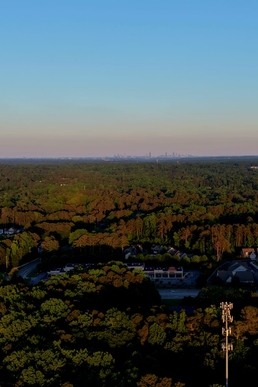 Aerial view over a local retail strip with the Atlanta skyline on the horizon